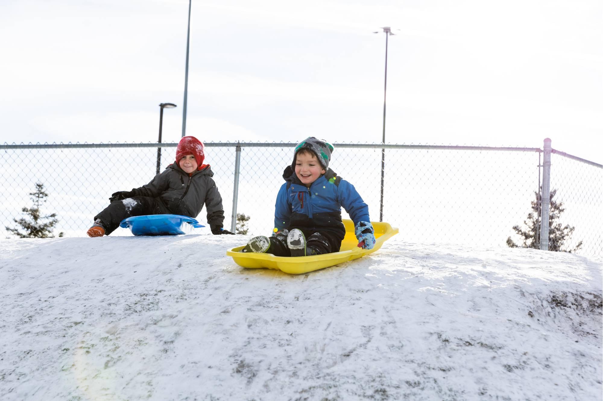 孩子们在儿童充实中心的小山上玩雪橇